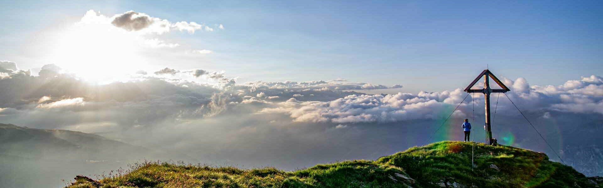 Wanderer beim Gipfelkreuz im Wipptal